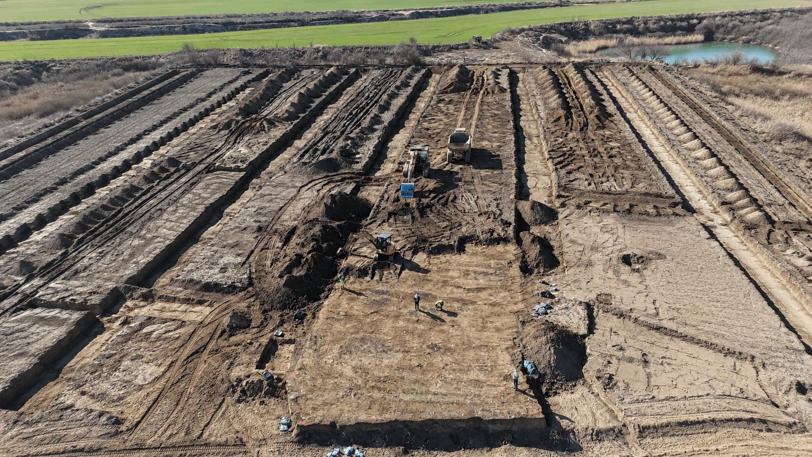 A Dark Glass Bead Emerges From a 1,600-Year-Old Village Buried Beneath a Saxon Gravel Pit