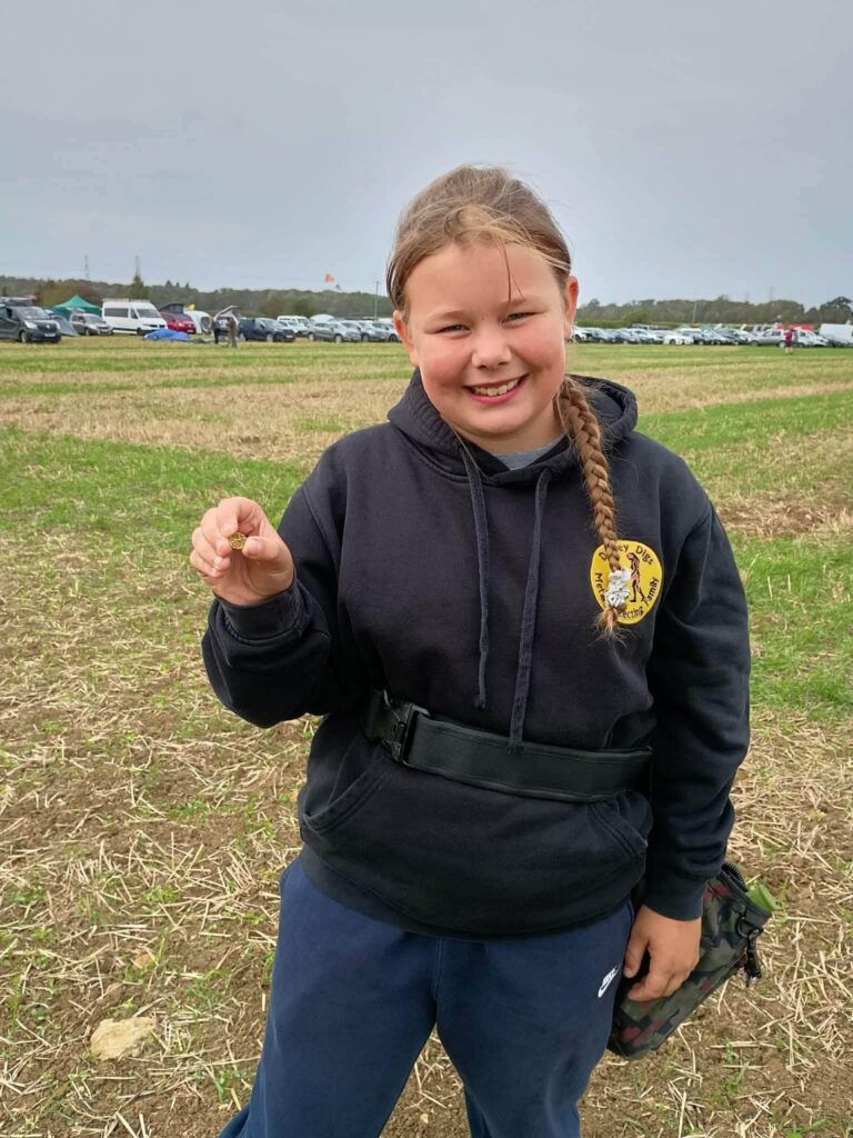 Eleven-year-old Darcey holding the Celtic gold quarter stater she found near Cirencester