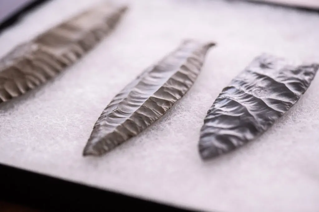 Replica Clovis and Cumberland stone spear points displayed side by side.