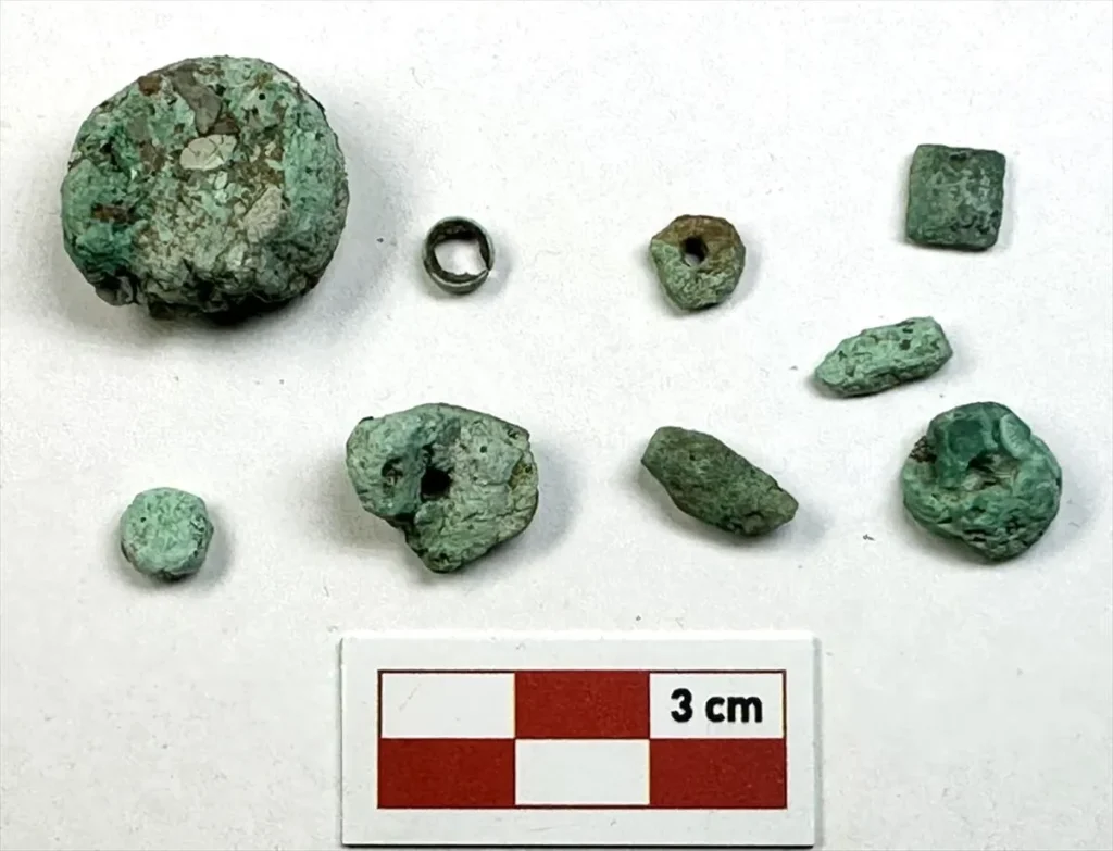 Worked and perforated malachite pieces with small copper finds from the Çayönü workshop.