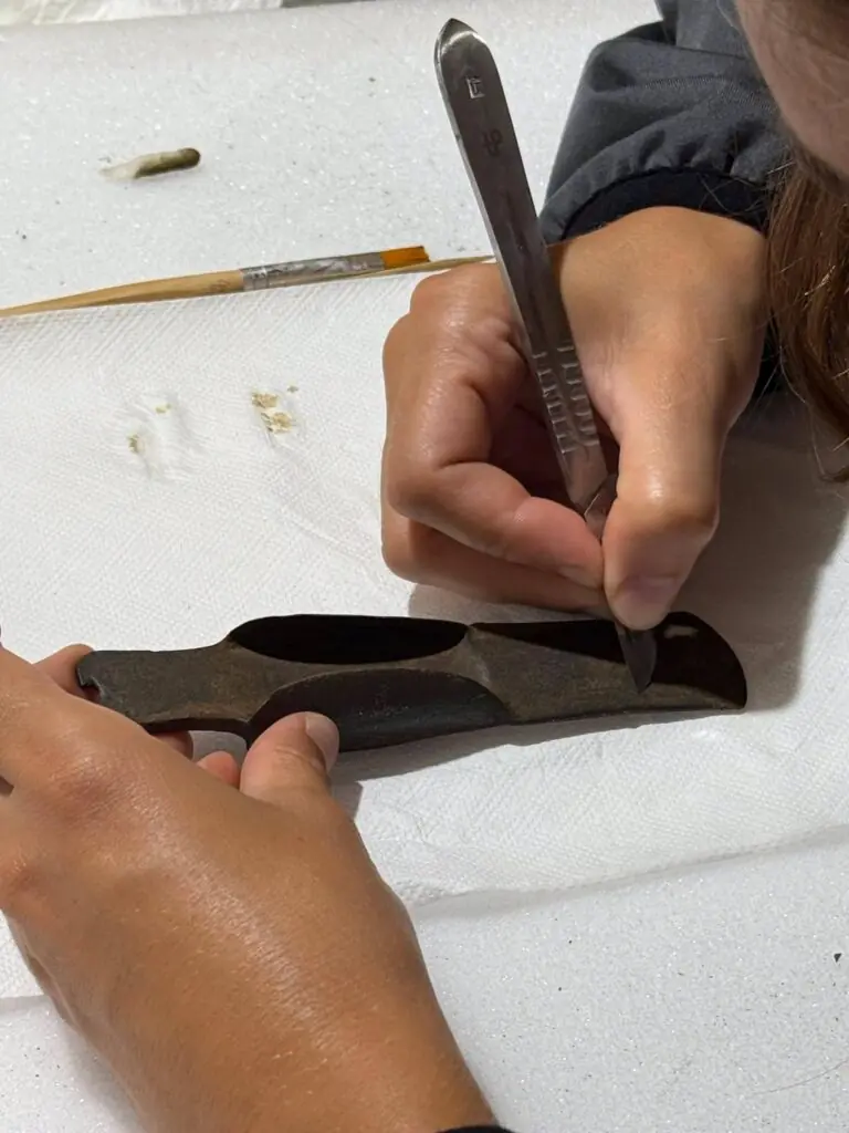 Conservator cleaning a bronze artifact recovered from Lake Mezzano