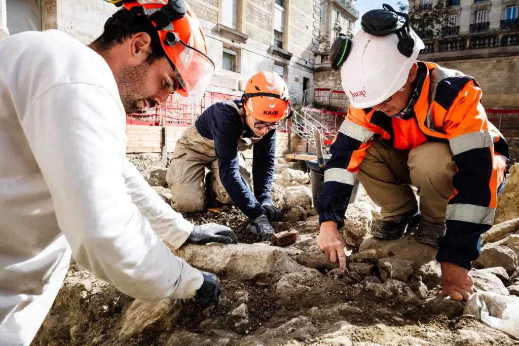 Archaeologists examining stones at the Hôtel-Dieu excavation in Paris.