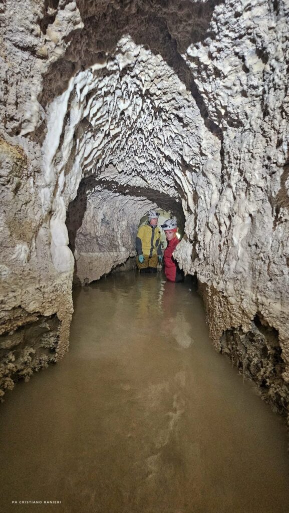 Two researchers examining the water-filled underground aqueduct near Trebula Mutuesca