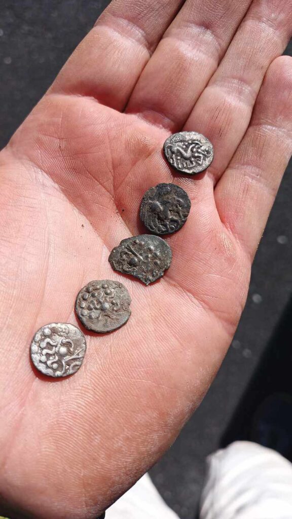 Five small Celtic silver coins resting in an archaeologist’s hand shortly after their discovery in Singen.