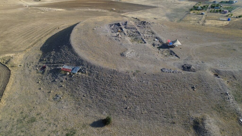 Drone view of Külhöyük mound and excavation trenches surrounded by dry farmland