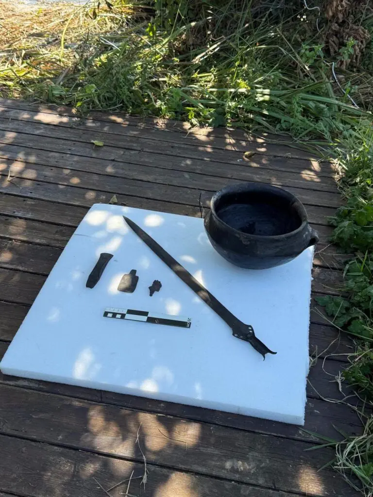 Bronze Age sword, pottery vessel and other archaeological finds displayed beside a measuring scale at Lake Mezzano.