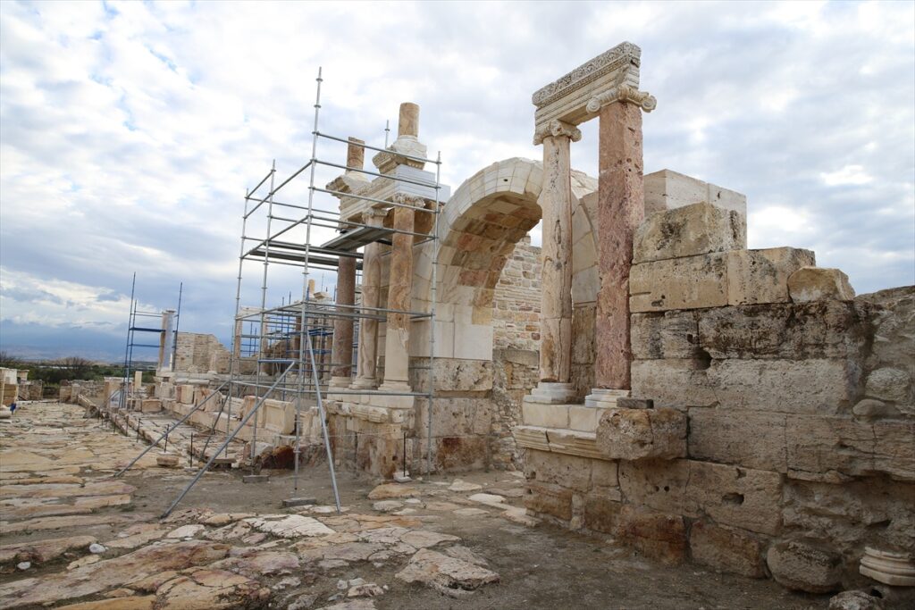 Decorated Roman columns, carved capitals and reconstructed stone arch surrounded by scaffolding at ancient Tripolis