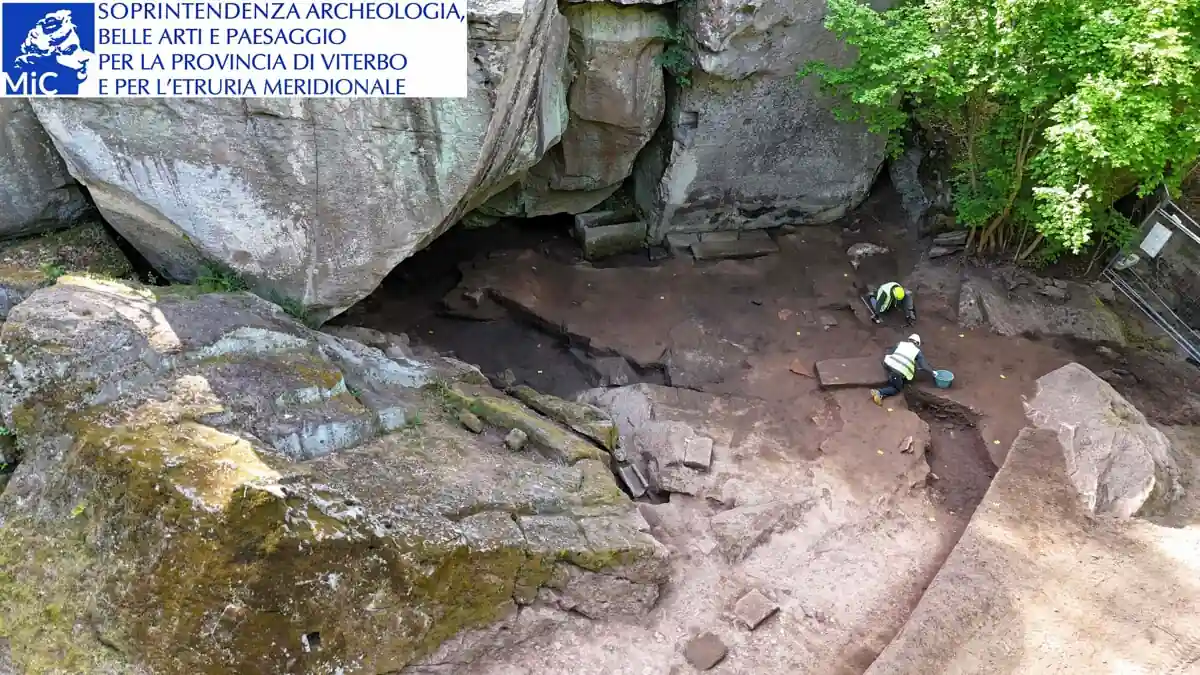 Aerial view of archaeologists excavating the ancient Sanctuary of Demeter among massive rock formations in Vetralla, Italy.