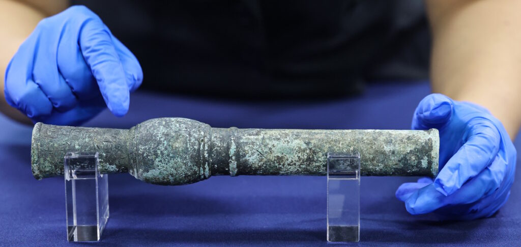 Researchers handling the bronze Hwangja Hwatong, Korea’s oldest known gunpowder weapon.