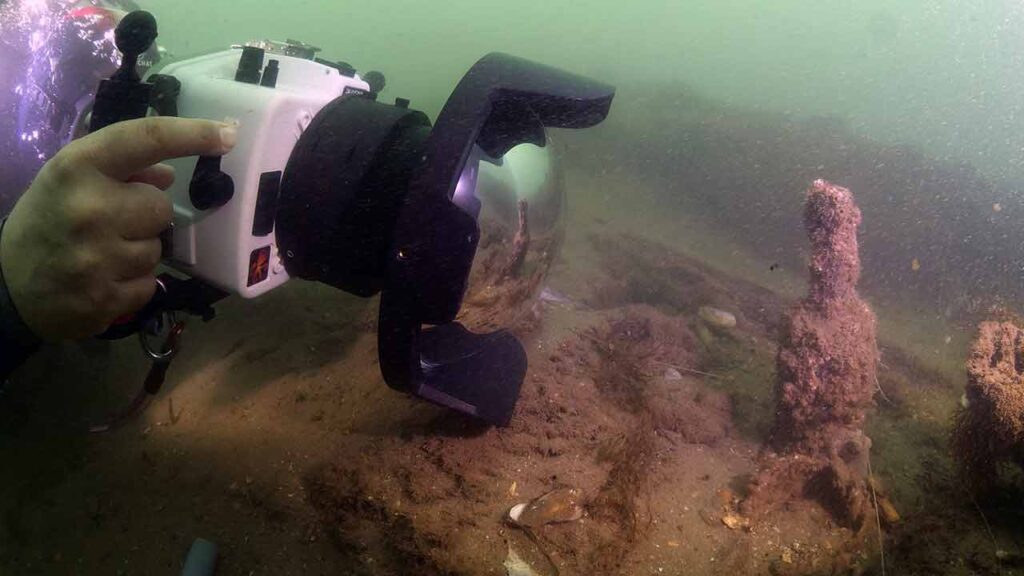 Underwater archaeologist photographing exposed remains in the Arade River during the MUSA project.