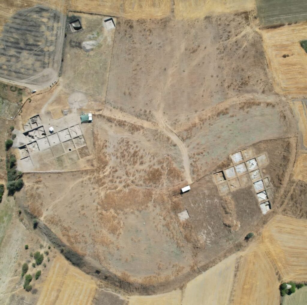 Aerial view of Tavşanlı Höyük showing excavation trenches and the surrounding landscape.